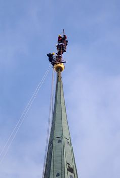 Many Industrial alpinists working at church tower