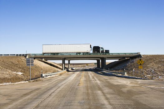 Tractor trailer truck on overpass.