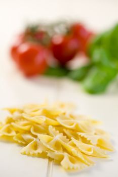 Pasta in the shape of a butterfly with vegetables in the background