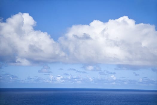 Horizon of Pacific ocean and blue sky with clouds.