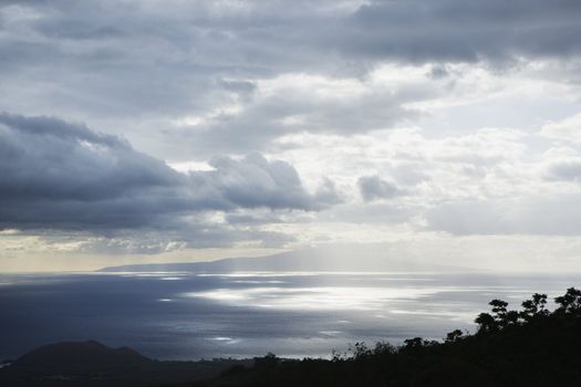 View of island in Pacific ocean with clouds from Maui, Hawaii.