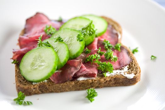 Healthy sandwich with roast beef and cucumber sprinkled with parsley
