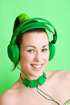 Pretty brunette on green background listening to music