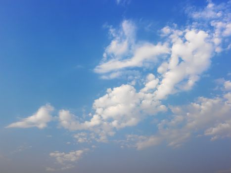 Skyscape of blue sky and white fluffy clouds.