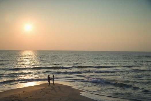 Birds eye view of couple on beach in Bald Head Island, North Carolina during sunset.