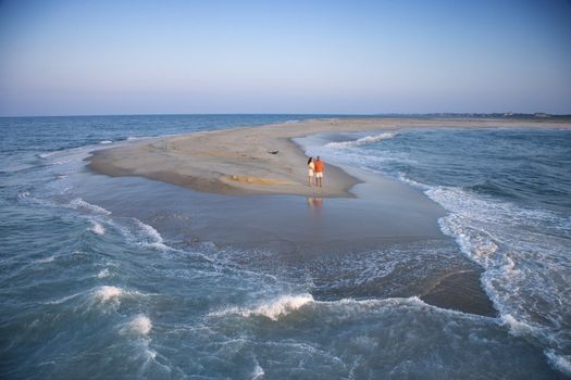 Birds eye view of couple on sandbar at Bald Head Island, North Carolina during sunrise.