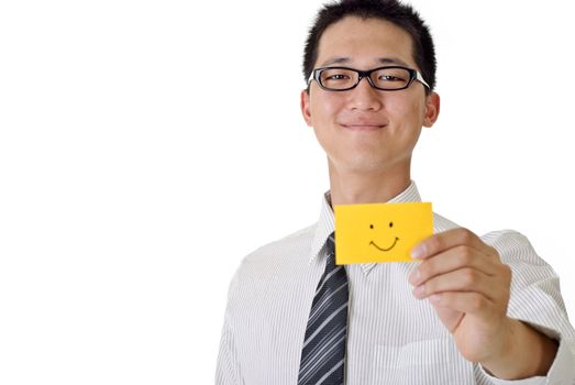 Smiling business man holding yellow card with smiling face, focus on face. Closeup portrait with white copyspace.