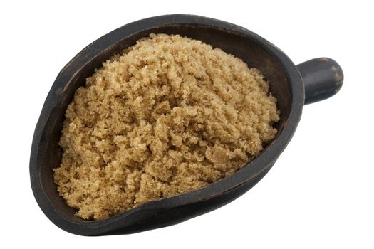 brown cane sugar on a rustic, wooden scoop isolated on white