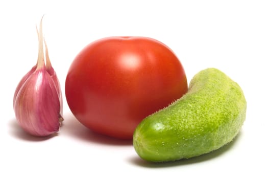 Garlic, tomato and cucumber closeup on a white background.