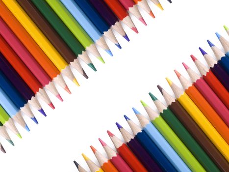 Colored pencils form a frame over a white background. Copy space.