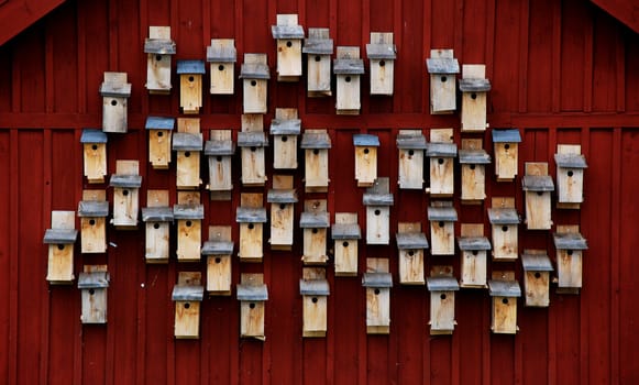 a group of nesting boxes on a red wooden wall