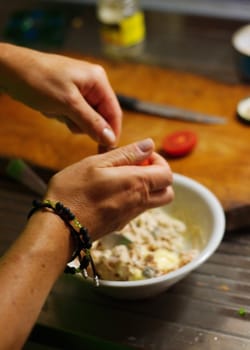 Hands cooking. Blurred background with bowl, counter and knife
