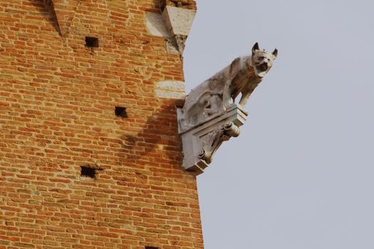 Gargoyle on a brick building in Pisa, Italy