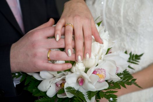 Hands with wedding rings and bunch of flower