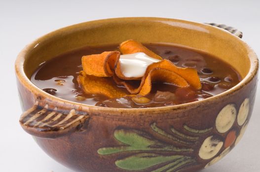 Bowl of spicy delicious black bean soup with sweet potato chips.