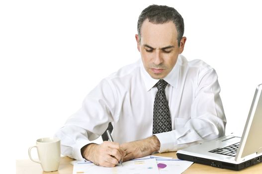 Serious office worker reviewing generic reports at his desk