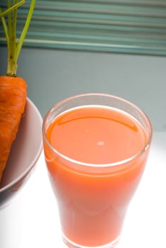 fresh and healty carrot juice unfiltered over a light table