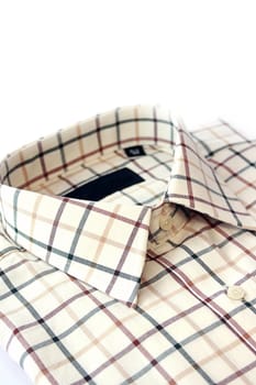 A close up view of a mans green, burgundy and yellow cotton checked shirt. Room for copy above.