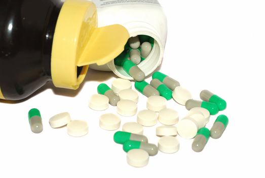Green pills and two bottles isolated on the white. 