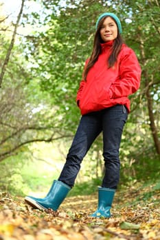 Fall colors. Young beautiful woman walking in autumn forest. 