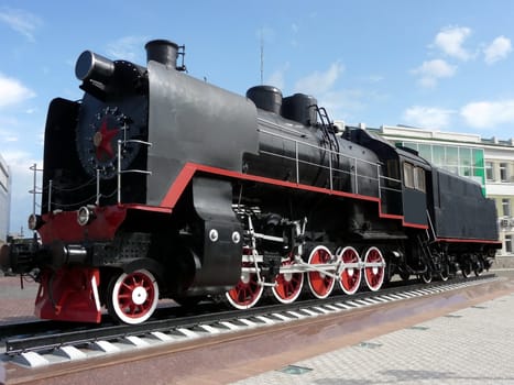 Old Russian black locomotive on a background of blue sky