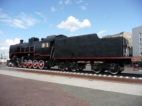 Old Russian black locomotive on a background of blue sky