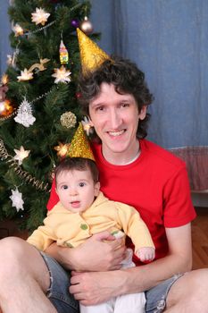 portrait of the happy father and son on New Year holiday near decorated christmas fir trees