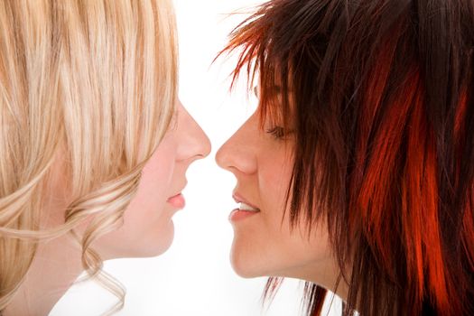 Blond and redhead girl kissing on isolated white background