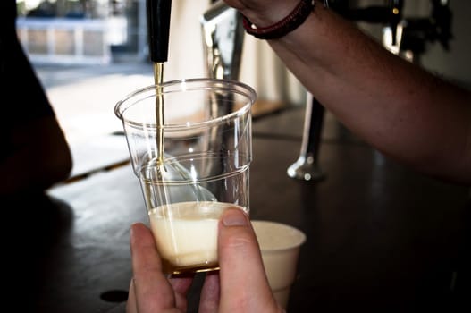 Beer spilled out into a plastic glass