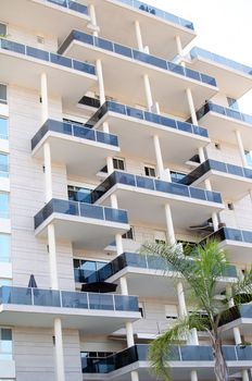 Front view urban apartment building with balconies .

