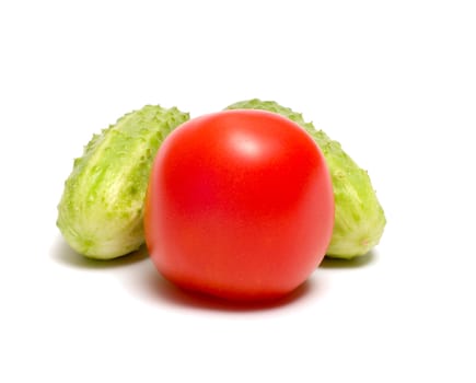 Tomato and two cucumbers it is isolated on a white background.