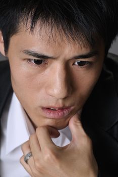 Worried young business man face, closeup portrait of Asian.