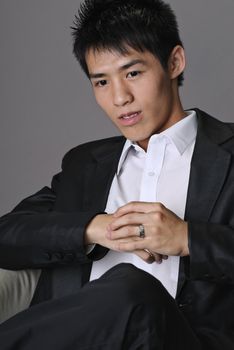 Closeup portrait of young business man sit on chair.