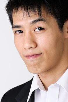Attractive business man of Asian with smiling face, closeup portrait with white copyspace.