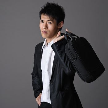 Portrait of Asian handsome young business man with briefcase.