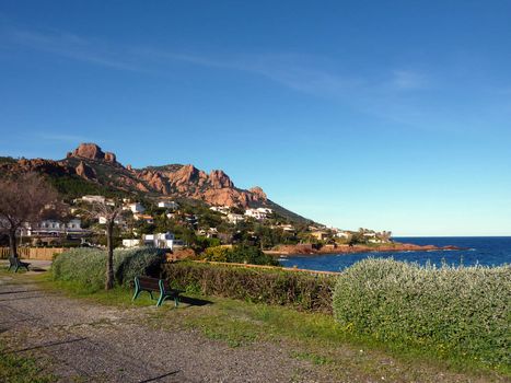 View of th red rocks of Esterel massif, south of France, from a little garden with benches