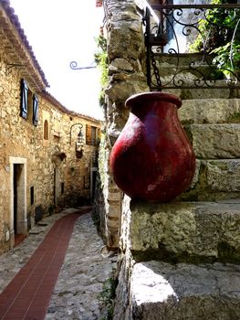 Street of Eze old village, south France, with a red pottery on the stairs