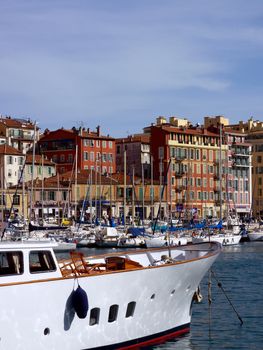 Big white boat with wood and colored buildings at the old port of Nice, France, by beautiful weather