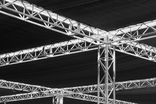 Steel girders, beams , and tarps that are part of a music concert roof or ceiling