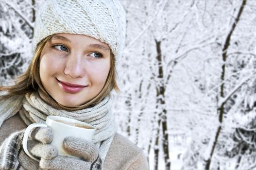 Teenage girl in winter hat with cup of hot chocolate