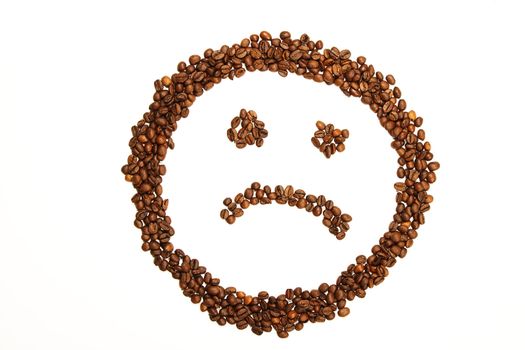 sad smiley made of coffee beans on white background