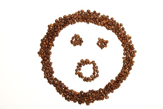 surprised smiley made of coffee beans on white background