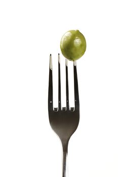 one green olive on a fork isolated on white background