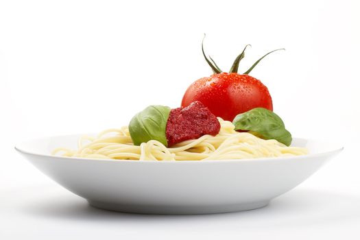 spaghetti in a plate with tomato, basil and sauce