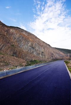 Asphalt road blue sky with clouds and mountains 