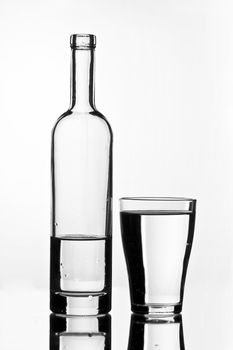 bottle with water and glass on white background