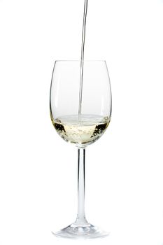 pouring white wine in a glass over a white background