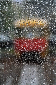 Drops of a rain on frontal flown down a tram which has stopped on a line