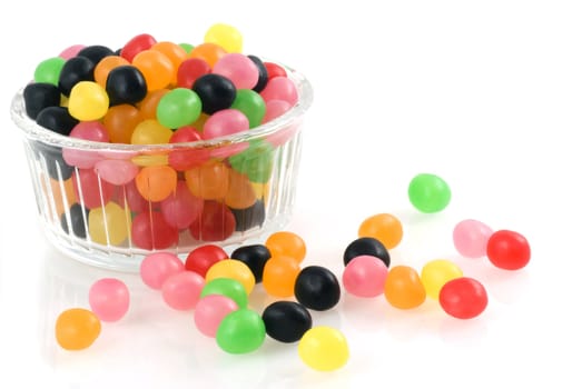 Bowl of glass filled with jellybeans isolated on white.