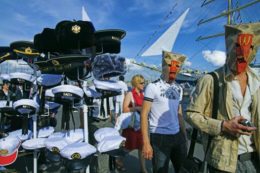 ST PETERSBURG - JULY 12: Young men walk by street vendor place and play fools at regatta festival near Neva river July 12, 2009 in St Petersburg, Russia.